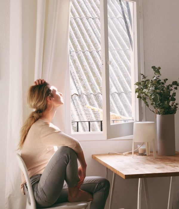 Woman feeling energized and calm in a bright room.